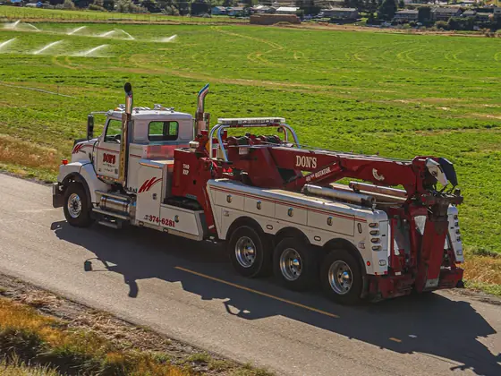 Aerial view of a Don's heavy wrecker on a rural road beside green fields