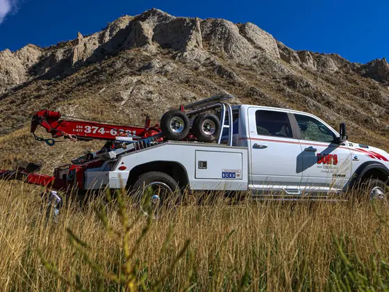 Don's Ram wheel-lift wrecker in tall grass below the hoodoos