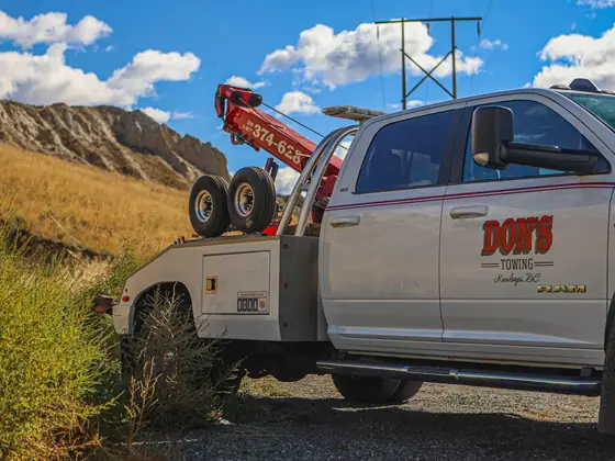 Rear view of a Don's Ram wheel-lift wrecker in the grass