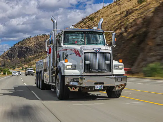 Don's heavy wrecker on the highway beside a rocky hillside