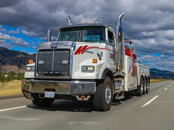 Front view of a Don's heavy wrecker driving on the highway