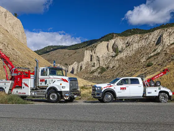 Don's heavy and light-duty wreckers parked along a mountain road