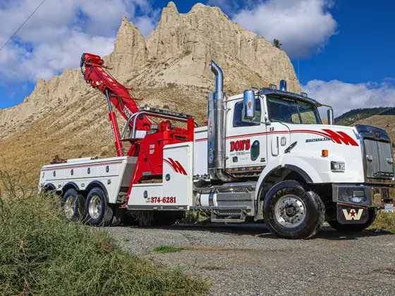 Don's heavy wrecker with its boom raised in front of the hoodoos