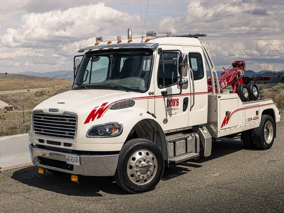 Don's medium-duty wrecker parked beside a concrete barrier