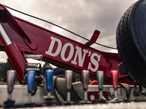 Red DON'S boom above a wrecker's hydraulic control levers