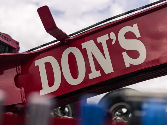 Close-up of a red tow boom with DON'S lettering
