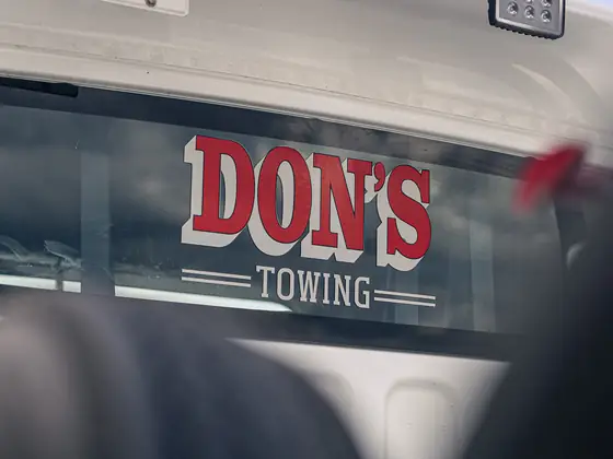 DON'S TOWING logo on a truck's rear window