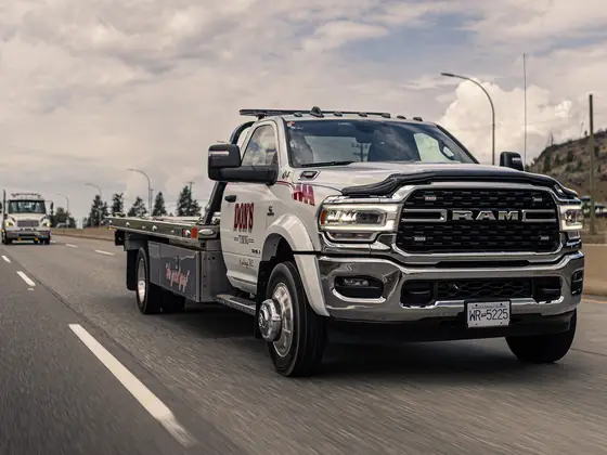Don's Ram flatbed tow truck driving on the highway