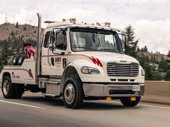 Don's medium-duty wheel-lift tow truck driving down a BC highway