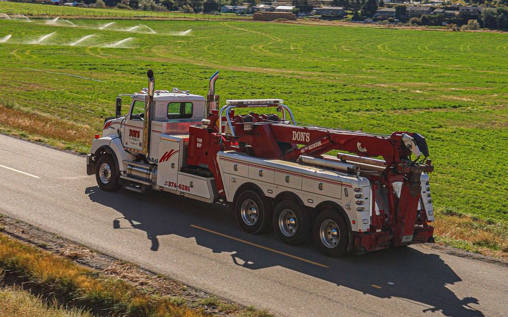 Aerial view of a Don's heavy-duty wrecker on a rural road beside green fields